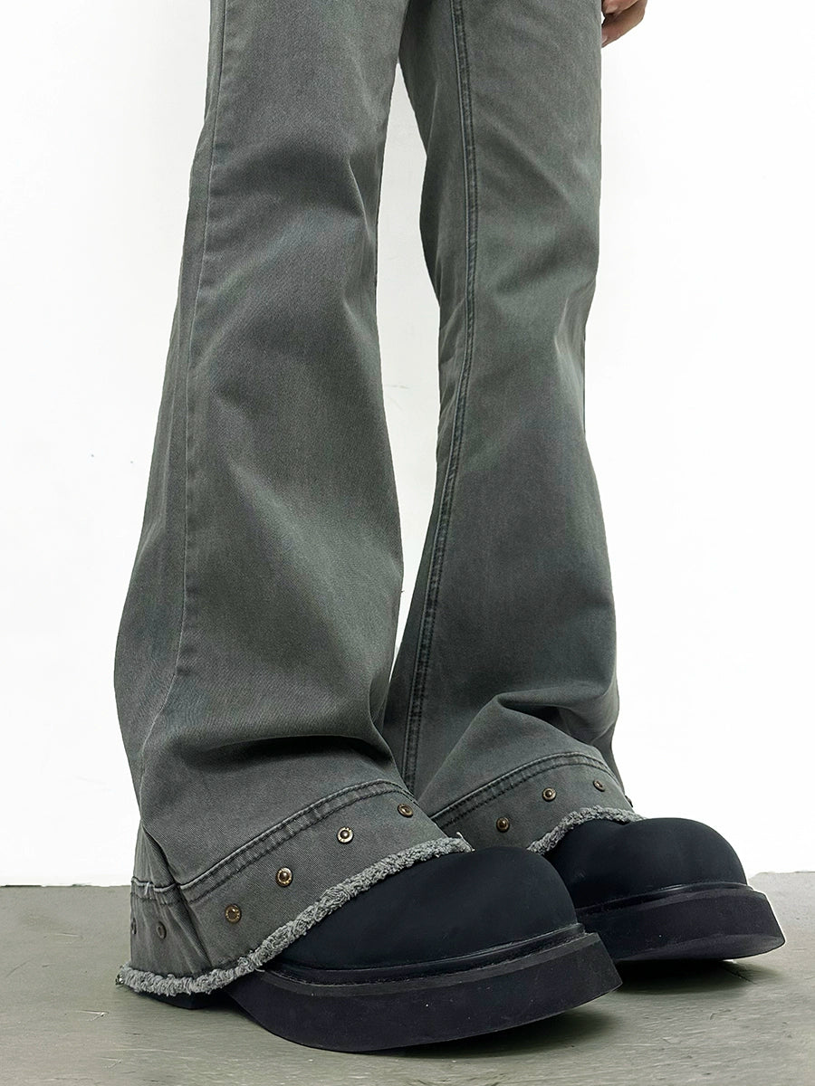 Gray jeans with black shoes worn on a light gray background