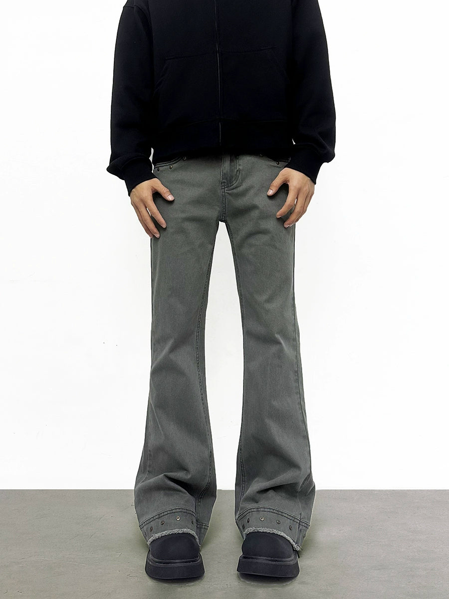Person wearing gray pants and a black jacket on a white background