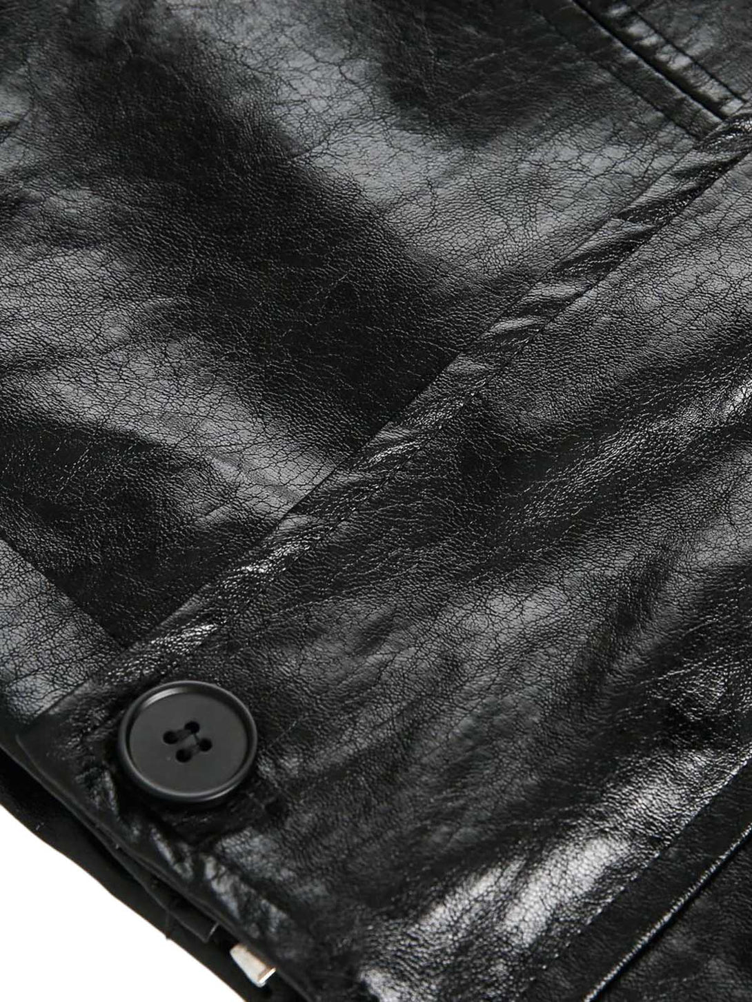 Close-up of a black leather jacket with a button, showing texture and wear.