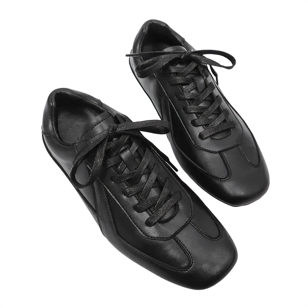 Pair of black leather sneakers on a white background