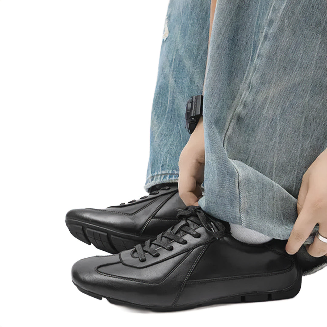 Person wearing black sneakers with a white background