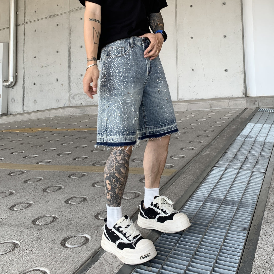 Person wearing denim shorts and black sneakers on a concrete floor.