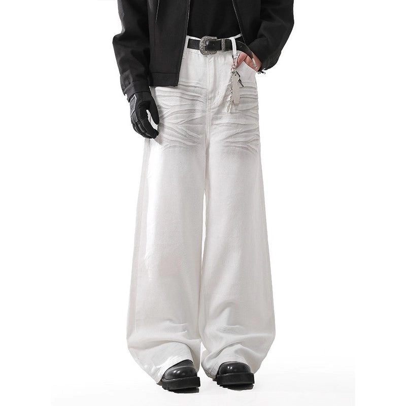 Person wearing white wide-leg jeans with a black jacket and shoes on a white background
